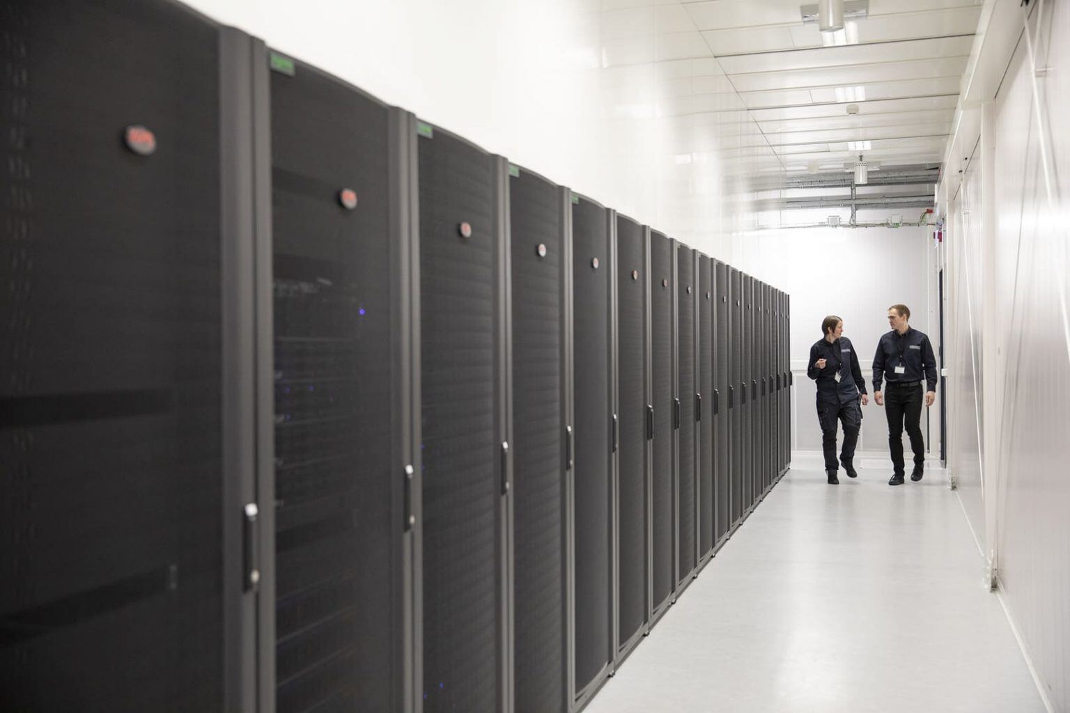 Sara & Oli from Verne walk alongside server cabinets